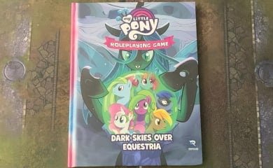 A photo of a copy of My Little Pony: Dark Skies Over Equestria on a gaming mat.