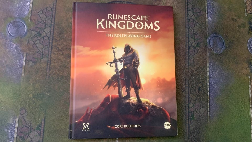 A screenshot of the Runescape Kingdoms The Roleplaying Game core rulebook on a gaming mat.