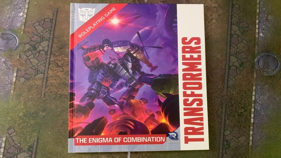 A copy of Transformers Enigma of Combination sitting on top of a gaming mat.